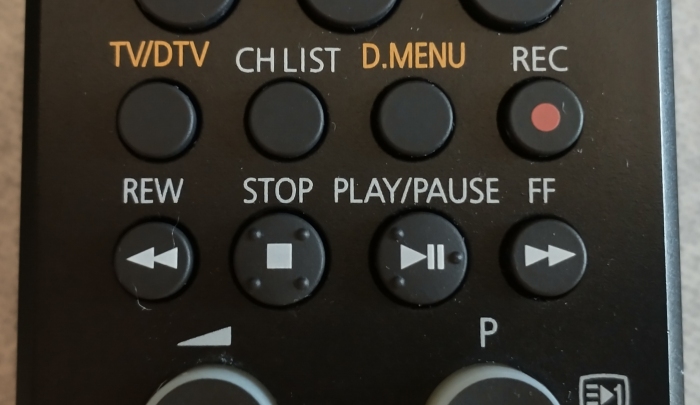 Close-up of TV remote control showing buttons labelled as described above